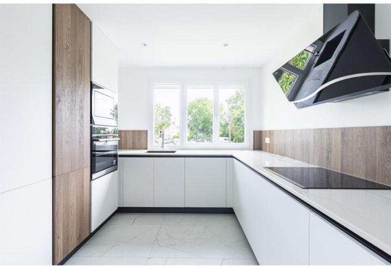 Cuisine moderne avec grand plan de travail en marbre noir, élégante et spacieuse, intégrant des éléments de design raffiné et épuré